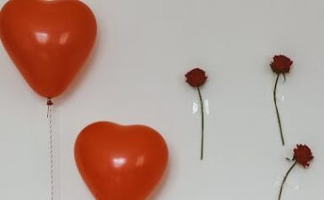 Elegant birthday setup with heart-shaped balloons and a decorated cake.