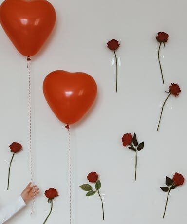 Elegant birthday setup with heart-shaped balloons and a decorated cake.